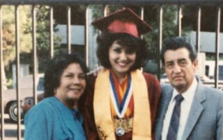 Adriana with her mother and father on graduation day