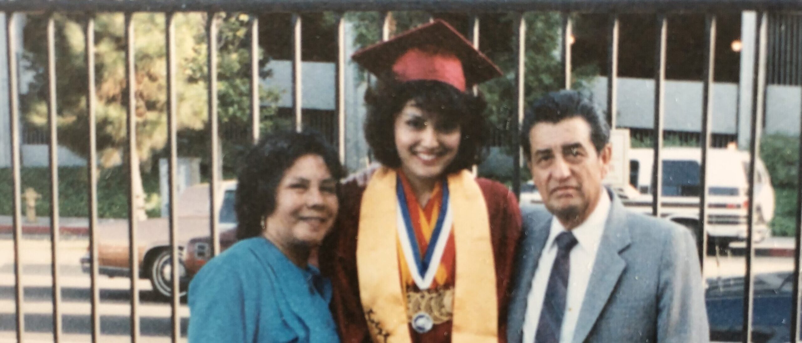Adriana with her mother and father on graduation day